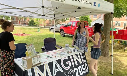 3 people at an Imagine 2050 event booth